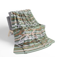winter forest design blanket in an earthy color palette of tan, brown, sage green and white on a chair