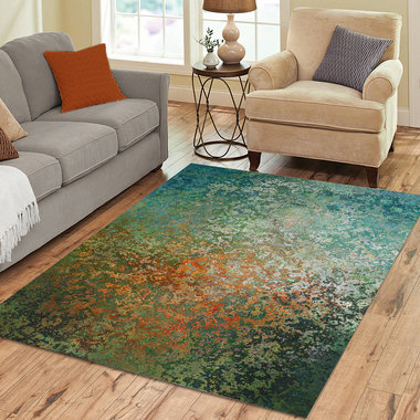 The rug in the image is rectangular and features an abstract design.  The color palette is predominantly earthy tones, with a blend of teal, green, orange, and brown hues.  The pattern resembles a mottled or distressed texture, almost like aged metal or stone with varying shades and speckles of color throughout. There's no clear, repetitive motif; instead, the colors blend and intermingle in a visually organic way creating an overall impression of depth and subtle movement. The style is modern and abstract,
