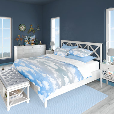 King duvet cover printed with fluffy white clouds on a blue and gray ombré sky background.